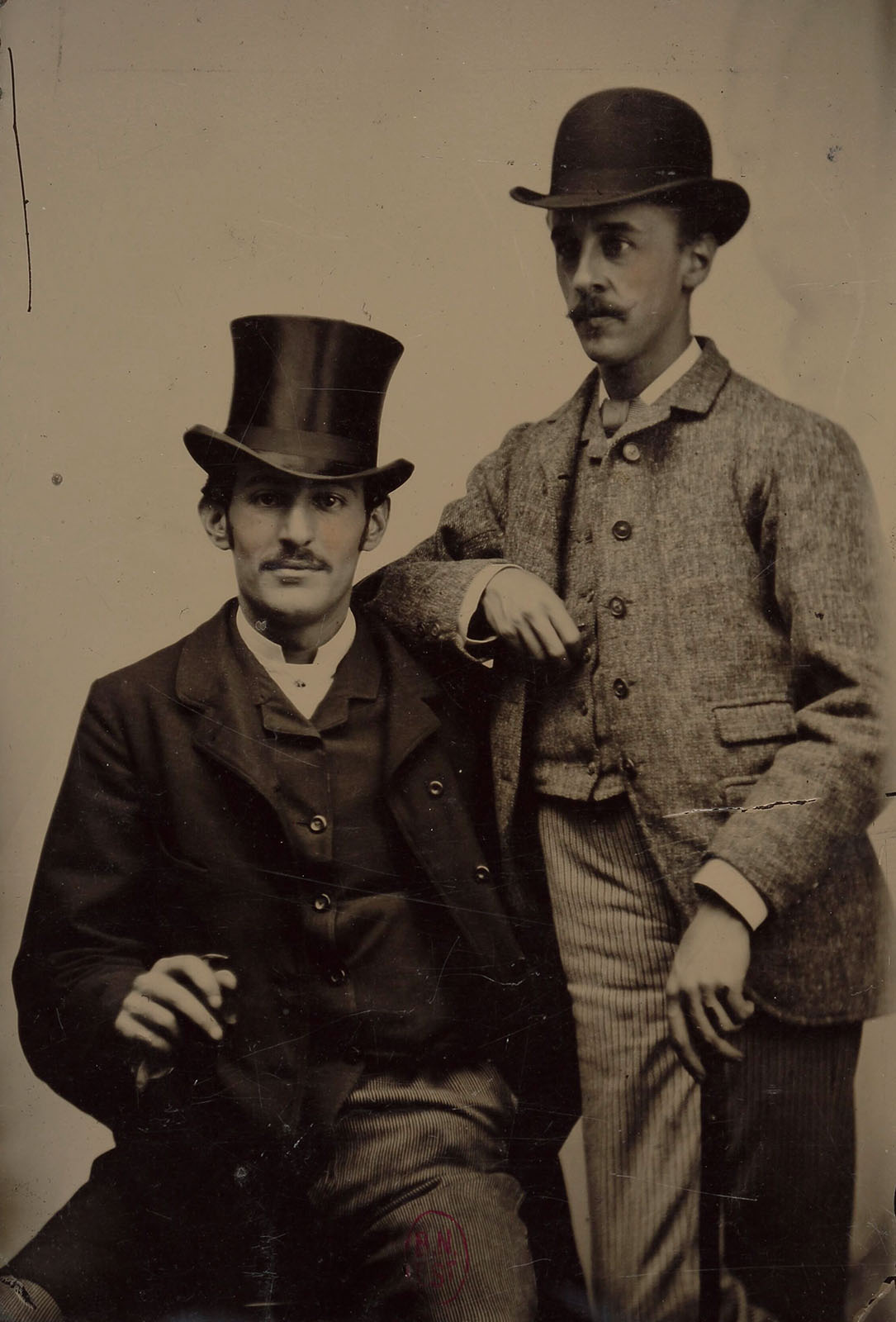 Ferrotype représentant deux hommes, l’un assis, l’autre debout.